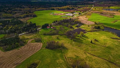 Timelapse aerial view of patchwork spring fields and farmland under golden light Stock Footage 310340000