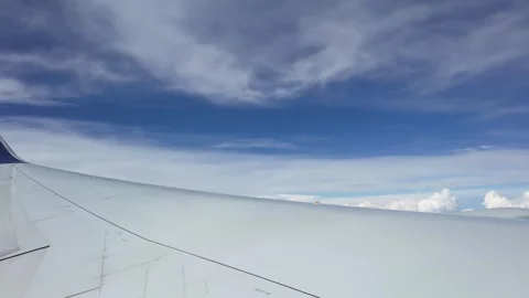 Timelapse of Airplane Wing Soaring Above White Clouds in Blue Sky Stock Footage 319030155