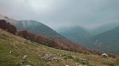 Timelapse of alpine mountain meadow with moving clouds and fog over autumn Stock Footage 324960794