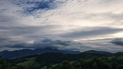 Timelapse of Altocumulus stratiformis clouds moving fast at evening. 動画素材 327594043