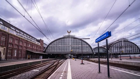 Timelapse of Amsterdam Central Train Station on a cloudy day with train traffic Stock Footage 78645571