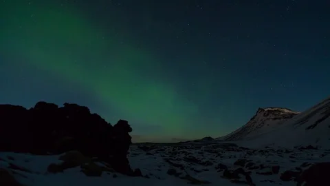 Timelapse of aurora borealis moving over snow covered mountains Stock Footage 73010622