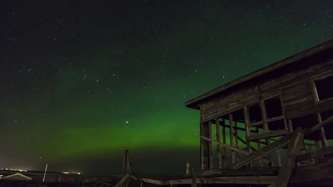 Timelapse of aurora borealis moving over abandoned house Stock Footage 73011931