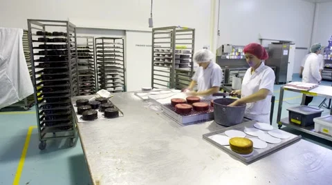 Timelapse of bakers at a commercial bakery decorating cake products Video stock 5186592