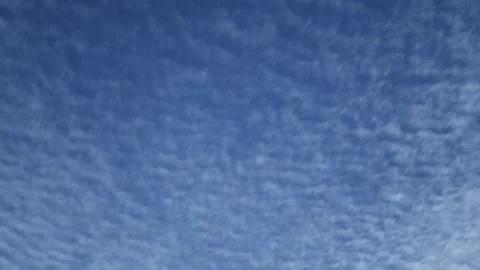 Timelapse of banded white clouds moving across a bright blue sky Stock Footage 331222743
