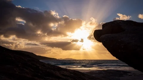 Timelapse at beach, clouds moving over the setting sun with shafts of light Stock Footage 125066702