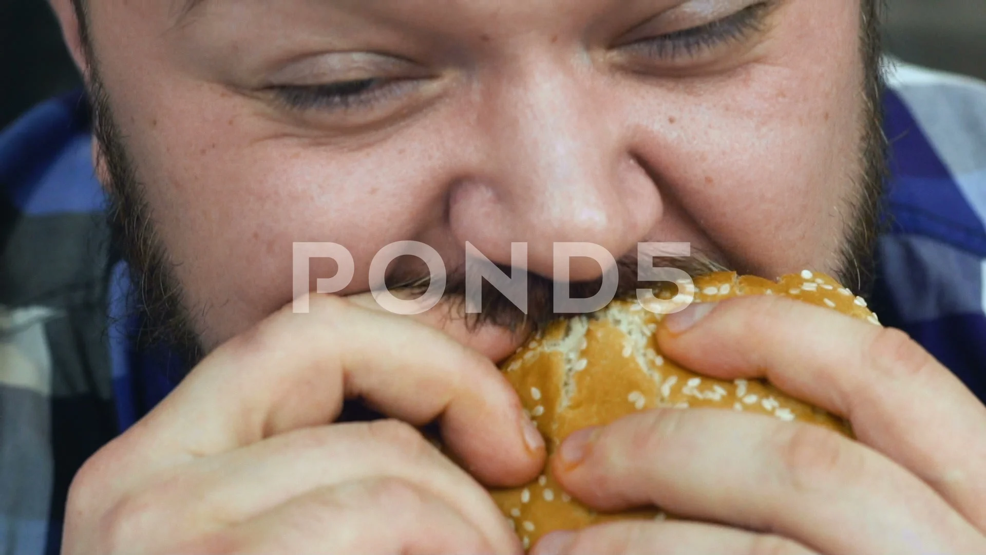 Timelapse bearded fat guy bites a burger he cooked. Man eats homemade food