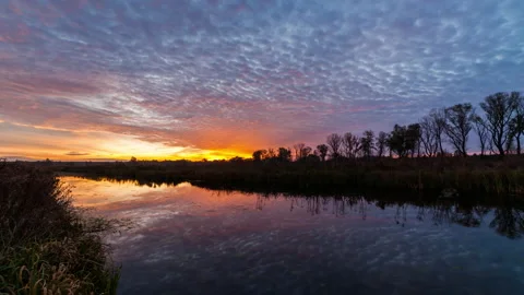 Timelapse of a beautiful dawn on the river. Reflection of clouds in water. Stock Footage 142053733