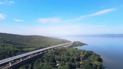 Timelapse of beautiful expressway in a green forest with a dam on the side. Stock Footage 164713548