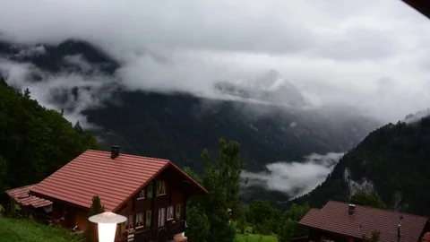 Timelapse of Beautiful Fog and Clouds Rolling Over Swiss Alps Village Stock Footage 80606948