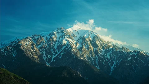 Timelapse. Beautiful snow-capped mountains, clouds fly over the peaks at sunset Video stock 239051725