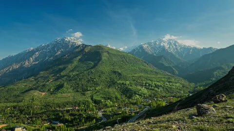 Timelapse. Beautiful snow-capped mountains, clouds fly over the peaks at sunset Stock Footage 239078406