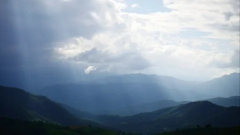 Timelapse of beautiful sun rays through the clouds over mountains Stock Footage 81109764