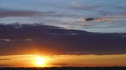 Timelapse of beautiful sunset - bright sun rays against a dark cloud Stock Footage 131007923