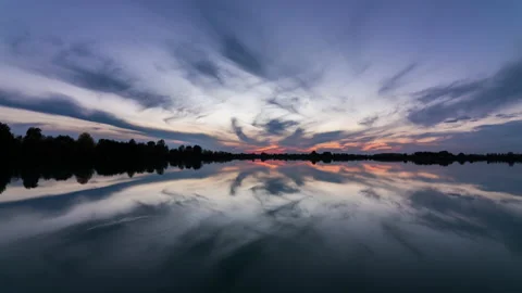 Timelapse of a beautiful sunset on the lake. Reflection of clouds in water. 動画素材 142054168