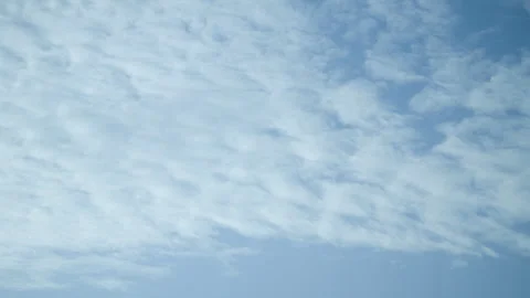 Timelapse Beautiful white altocumulus clouds on bright blue sky background Stock Footage 339116100