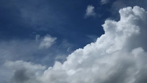 Timelapse of beautiful white clouds drifting across the dark blue sky Stock Footage 336700526