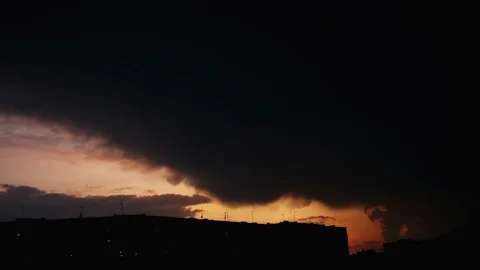 Timelapse of big black rain cloud covers the city at sunset, it starts to rain Stock Footage 110751331