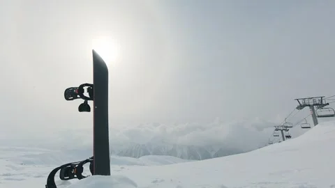 Timelapse black Snowboard base vertically in snow under cloudy winter sky w.. Stock Footage 324950356