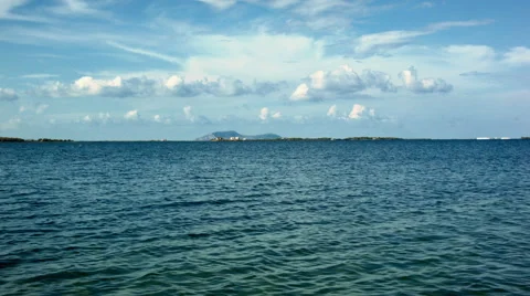 Timelapse of blue sea and sparse clouds in the distance Stock-Footage 52055987