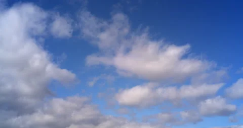 TimeLapse - Blue sky and fluffy clouds move lower right to the upper left Stock Footage 169307124