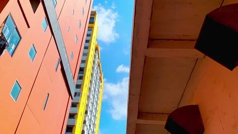 Timelapse of blue sky with moving clouds above colorfull apartment buildings Stock Footage 330571979