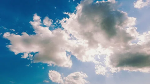 Timelapse blue sky with moving white clouds covering the sun Stock Footage 162884212