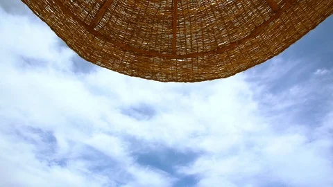 Timelapse of blue sky with white moving clouds, sun parasol standing on beach Stock Footage 107912048