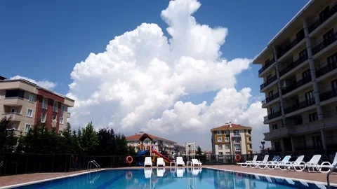 Timelapse. Bright blue sky. White clouds. Red tiled roofs of houses. Stock Footage 133355299