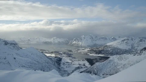 Timelapse of broad clouds passing by on sky above snow covered mountains Stock Footage 124237714