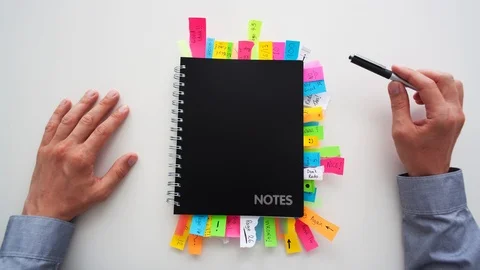 Timelapse of a businessman putting post it notes in to a notepad Stock Footage 112304874