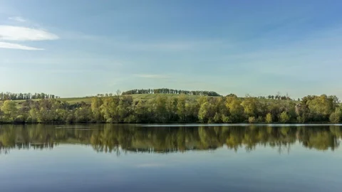 Timelapse of calm lake surface with views of surrounding countryside Stock Footage 130088799