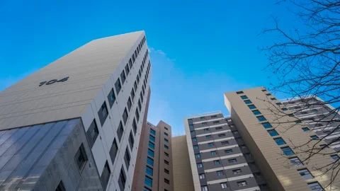 Timelapse capture of clouds flowing across the sky of an apartment complex 库存影片 260879099
