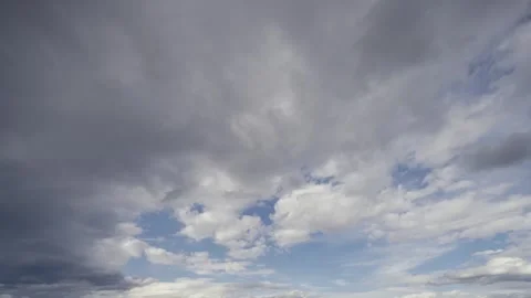 Timelapse captures the dramatic motion of contrasting clouds over a serene blue Stock Footage 330615982