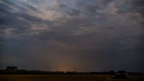 Timelapse capturing flashing lightning and towering storm clouds at dusk Stock Footage 301409757