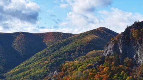 Timelapse capturing lush mountain landscape with autumn colors and passing Stock Footage 318869686