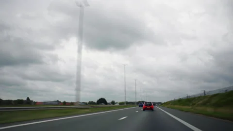 Timelapse of a car is driving down a highway with a cloudy sky in the background Stock Footage 285160245