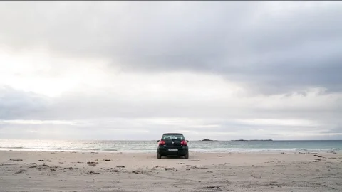 Timelapse of car standing on the beach with clouds moving fast Stockbeeldmateriaal 89946977