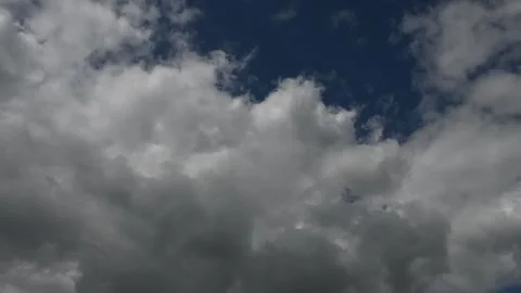 Timelapse of churning white and grey summer clouds in a dark blue sky Stock Footage 313531749