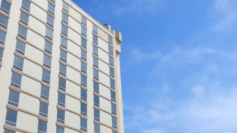 Timelapse Clear Blue Sky With White Wispy Clouds Against Building With Cloud Stock Footage 128398738