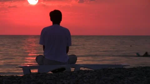 Timelapse clip of man sits on coast and looks at sundown Stock Footage 10732136
