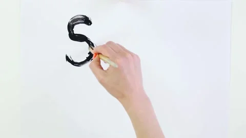 Timelapse. close-up, hand writes slogan - Stop Racism - with brush, using black Stock Footage 132005041