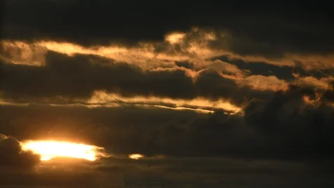 Timelapse - Close up of yellow sunset behind dark clouds Stock-Footage 94477512