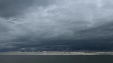 Timelapse of a cloud filled sky above a large lake with small waves Stock Footage 335550001