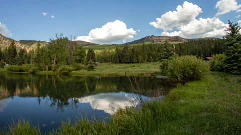 Timelapse of cloud movement over a lake in a valley Stock Footage 154944369