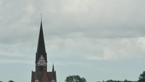 Timelapse of cloud movement over an old medieval church with a clock Vídeos de archivo 255480347