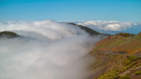 Timelapse of cloud waterfall spilling over mountain ridges, telephoto lens, Tene Stock Footage 335765155