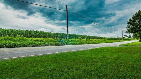 Timelapse of Clouds Above Corn Field and Street 스톡 동영상 93967238