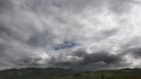 Timelapse clouds above rugged mountain ridges shifting light evening weather Stock Footage 339566868