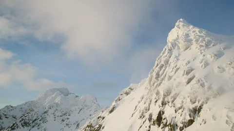 Timelapse of clouds and fog floating around tall peaks of snow covered mountains Stock Footage 124237729